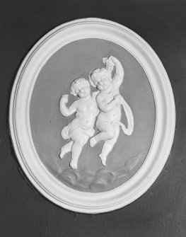 Interior. Entrance hall, detail of oval wall plaque with putti