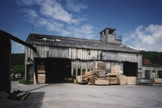 View from E showing sawmill/boathouse with rooftop observation tower at N end of the building.