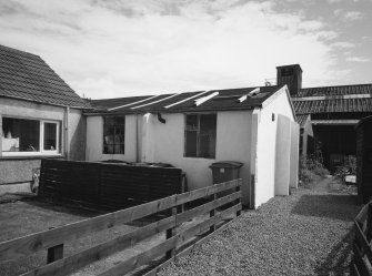 View from N of re-used Air-Ministry Standard Hut with boathouse in the background.