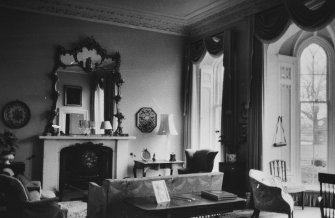 Cumstoun House, interior.
General view of drawing room, showing fireplace with elaborate overmantle mirror and bay windows.
