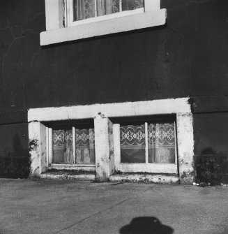 View of street elevation coal chutes adapted as windows and fitted with curtains.