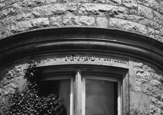 Detail of lintel inscription above SE tourelle's paired windows.