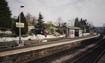 View from SW of N-bound platform, including waiting room and shelter, and station garden