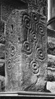 General view of cross-shaft showing carvings on front and left side of stone.