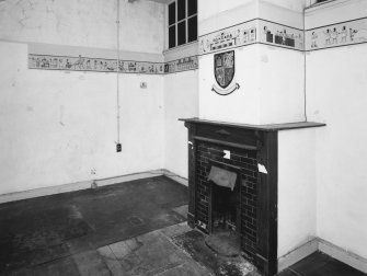 Donibristle airfield, view of interior of former officers mess from North showing painted cartoon dado frieze and fireplace.  Above the fireplace is imitation cartoon armorial panel.