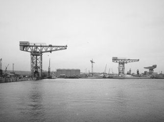 General view from S of three cranes around Main Basin: (left to right) 250-ton crane (Sir William Arrol), 100-ton crane (Sir William Arrol) and a smaller Stothert and Pitt crane.  The 100-ton and 250-ton cranes were demolished in 1992.  
Photosurvey 19-FEB-1991