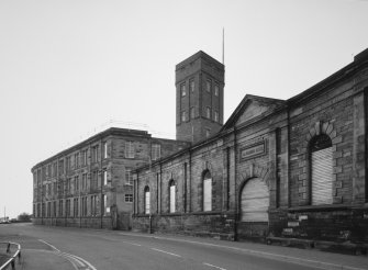 View from NE of S section of N part of works (showing M Nairn plaque), and S part of works, including brick-built water tower