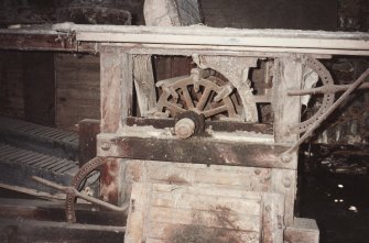 Detail of threshing machine (with side cover removed) showing threshing drum, concave ajusting levers and straw walkers, photographed 9 May 1994