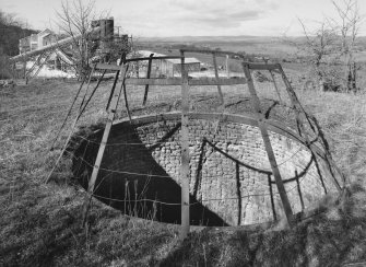 Detailed view from E of mouth of pot of old lime kiln, with lime works visible in background