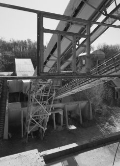 View from N at middle level of shaft kilns, showing the conveyor taking crushed limestone to the former kilns for storage.  The base of the crusher is visible, as is a surviving portion of one of the old conveyors used to charge the shaft kilns when they were in operation