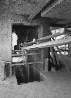 Detailed view of base of one of the two shaft kilns, showing bottom of hopper and belt conveyor