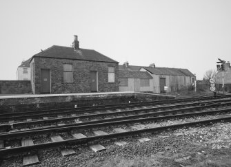 View from E of outbuilding and shed at end of N-bound platform at W side of station