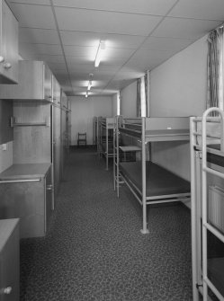 Interior view of 1935 Barrack Block showing ground floor dormitory with bunk beds and storage cupboards from S.