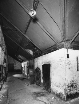 Interior, from North West, along bottom of central and North kilns, showing firebox doors and sheet metal sides beneath kiln