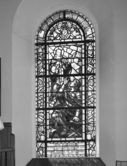 View of a large stained glass window to the right of the pulpit
