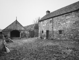 View across courtyard from W of S corner of main block of steading, showing entrance to former Turnip Shed (left)