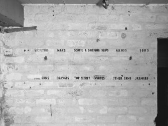 Interior.
Detail of brick wall with painted headings to record sortie details.