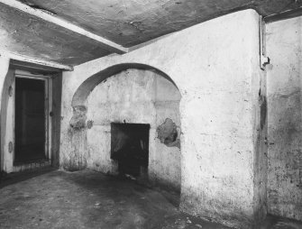 Detail of fireplace on North wall of kitchen in North apartment on ground floor.