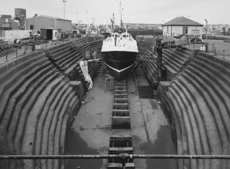 General view into North Harbour dry dock, Peterhead, showing boat undergoing repairs.