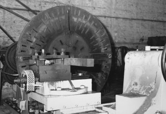 Aberdeen, York Place, Hall Russell Shipyard.
North end of East bay in former engine works. Detail of 4-jaw chuck/face plate (2.4m diameter, gap 1.0m wide, swing 2.5m radius) on flat belt driven cone-pulley lathe.