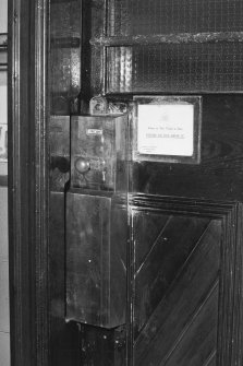 Interior. Detail of typical coin-operated brass lock on cubicle door