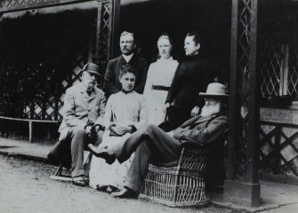 Ardimersay Cottage, Islay.
Family portrait of John and Lucy Ramsay and friends sitting on porch of cottage.