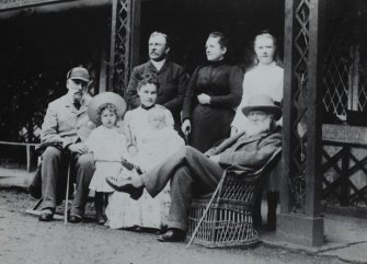 Ardimersay Cottage, Islay.
Family portrait of John and Lucy Ramsay and friends sitting on porch of cottage.