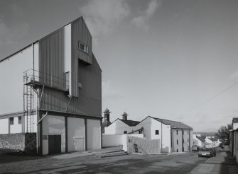 Bowmore Distillery
Oblique view from SW along SE side of distillery, overlooking School Street, with working floor maltings in middle distance, and grain store in foreground