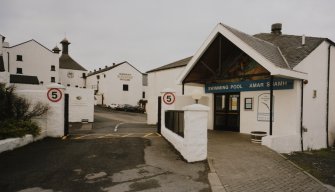 Bowmore Distillery
View of main entrance to distillery from NE, showing the adjacent indoor Bowmore Swimming Pool (right), which is heated using waste heat from the distillery