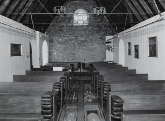 Interior. View from E showing boarded walls and pews from the vhurch on The Oa