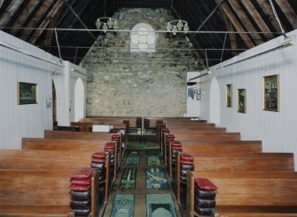 Interior. View from E showing boarded walls and pews from the vhurch on The Oa