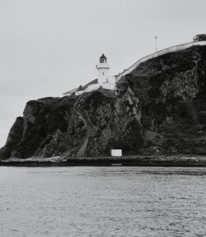 Islay, McArthur's Head Lighthouse
General view of lighthouse and compound from N (viewed from a boat at sea), showing cliff-top location, steep steps down to jetty, flagpole, and compound wall