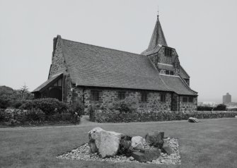 View from NE showing entrance porch and spire