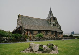 View from NE showing entrance porch and spire