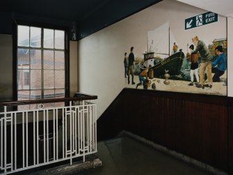 Interior. View of staircase landing with mural from North