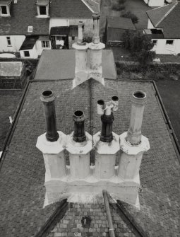 Detail from lighthouse onto octagonal chimney stack and fireclay cans on principle's house.