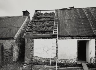 View showing original thatch revealed under removed cast-iron sheet.