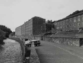 General view from S of Mill No.3, in the context of the River Clyde (left) and the Institute (right), with the foundations of Mill No.4 in the foreground (right)