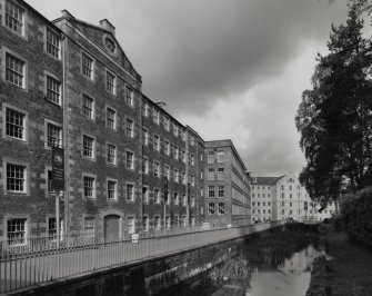 View from E of lade as it passes in front of Mill No. 3, with Mills No. 2 and 1 in the distance