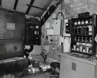 Interior. View within winding-engine house showing electrical switchgear (left), and lamp-battery chargers and self-rescuers (right).