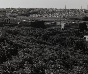 Elevated general view from NE (on Nitroglycerine Hill No. 2 (NE, NS23NE 1.03]) of Catridging Houses (AZF4 and AZF3) to the left [NS 2879 3970], connected by ropeway-gantry. The rubble in the background is the remains of recently demolished magazines