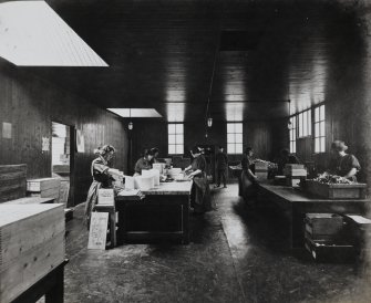 Photographic copy of Interior view in: Blasting Department - Women operatives in Packing house for gelatinous explosives.