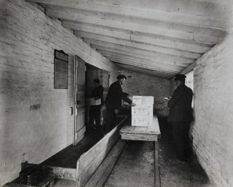 Photographic copy of Interior view in Blasting Department. Discharging cases of 'Samsonite' into storage magazines