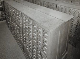 Interior.  Elevated view within library showing wooden cabinets containing drawers of index cards, cross-referencing Reports with reference books,journals and other records