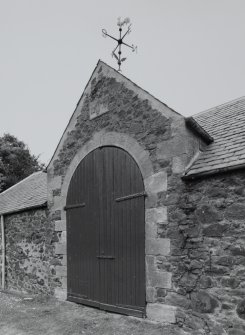 Detail of steading main arched cart entrance with  plaque inscribed "1877  WJ" with weathervane at the apex