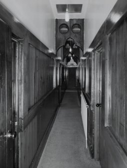 Interior. first floor View of corridor from N showing panelling and cusped screens