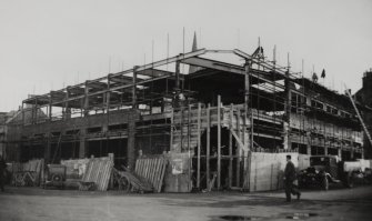 Copy of historic photograph showing view from NW of building during early stages of construction.
