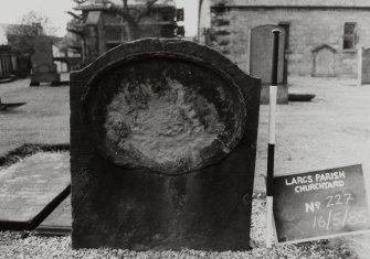 View of flat top headstone with slightly curved central feature  and central horizontal oval. Inscription illegible.
Largs Parish Churchyard no 227
