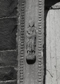 Detail of figure on left jamb of doorway