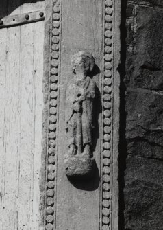 Detail of figure on right jamb of doorway